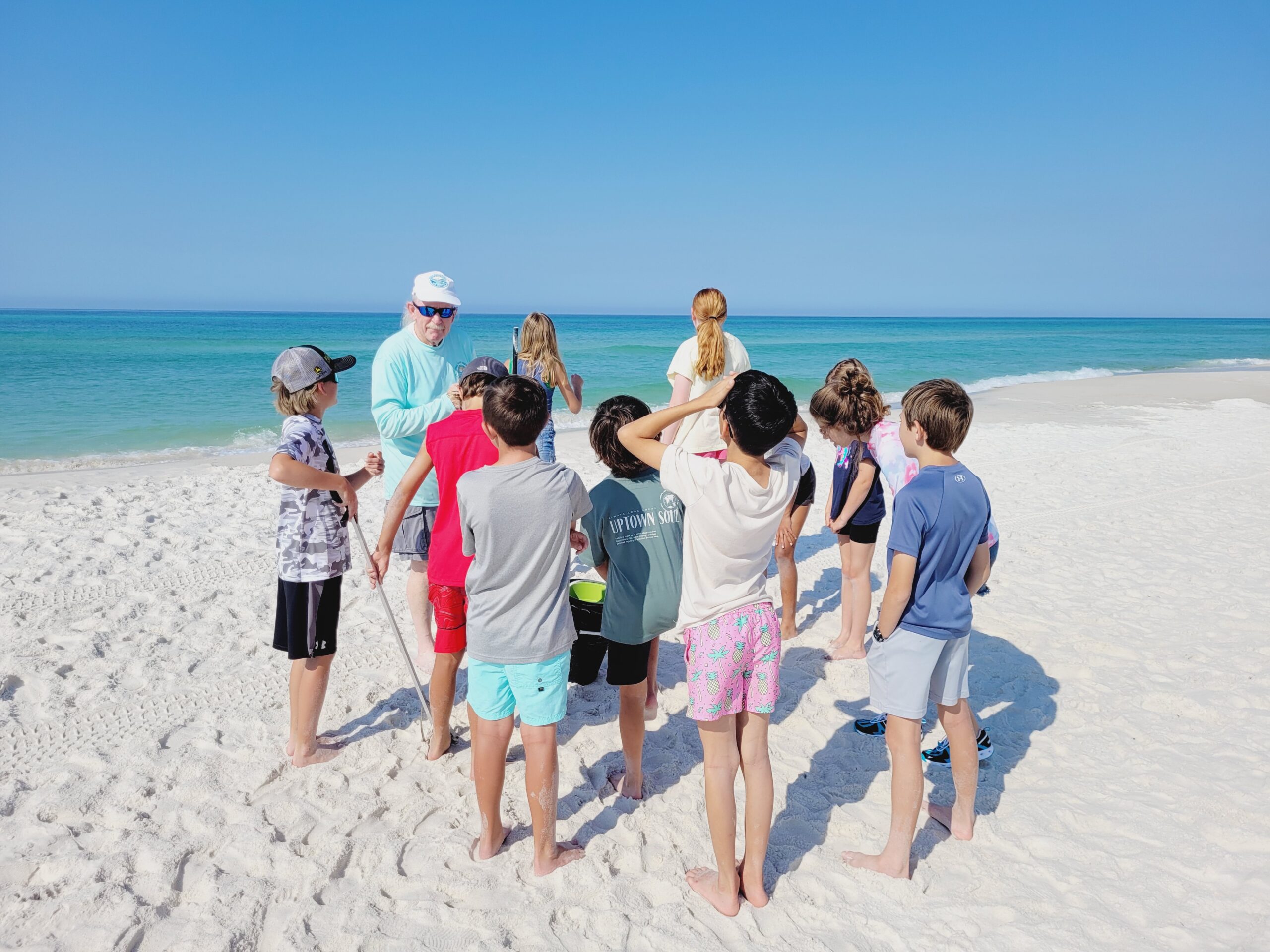 A Volunteer Beach Ambassador teaching students about beach cleanup.